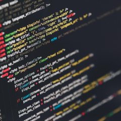 数据校对人员对着两块屏幕逐期比对公开开奖记录与站内表格，房间光线偏暗只有屏幕发亮